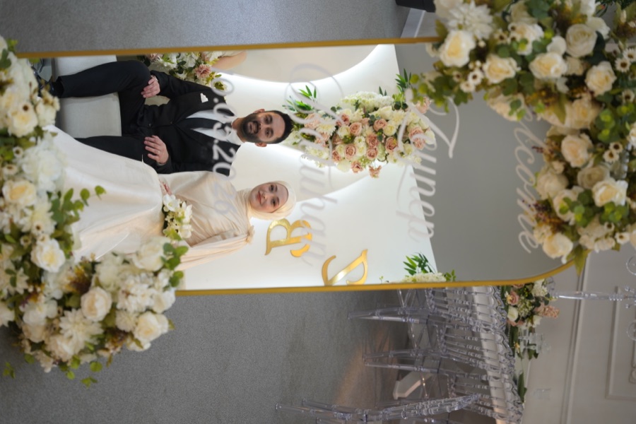 Zeynep ve Batuhan çiçekli fotoğraf çerçevesinde oturuyor